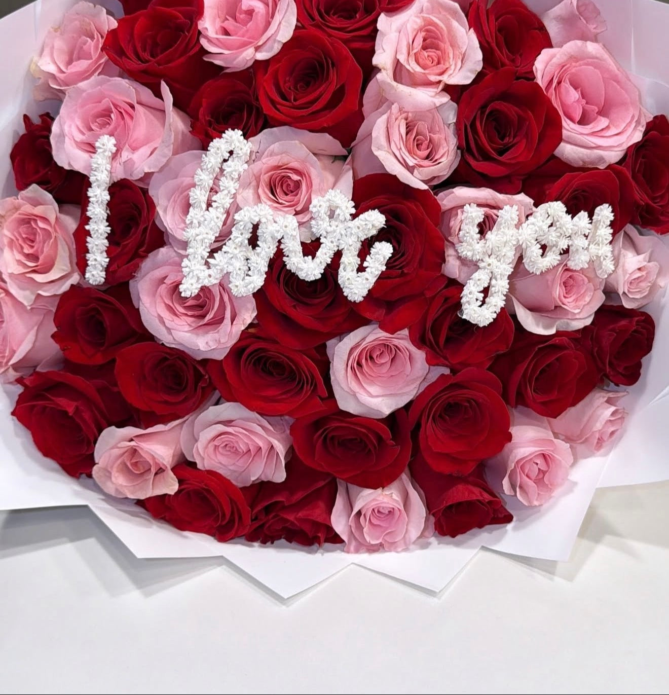 Bouquet of red and pink roses with 'I love you' in the center