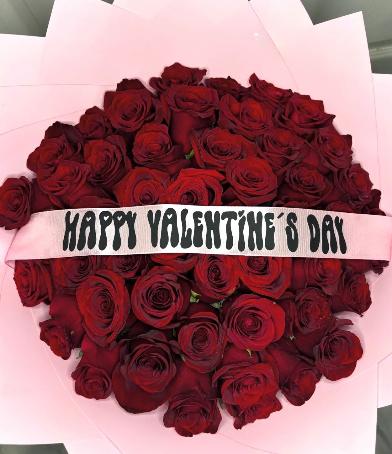 Bouquet of red roses with pink wraps