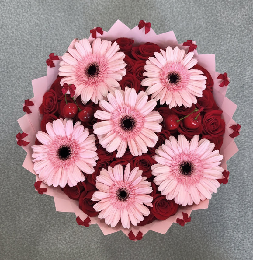 Bouquet of pink flowers and red roses on a wooden floor