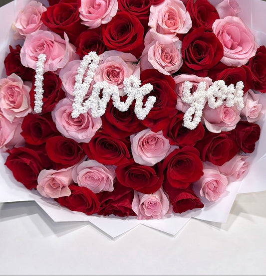 Bouquet of red and pink roses with 'I love you' in the center