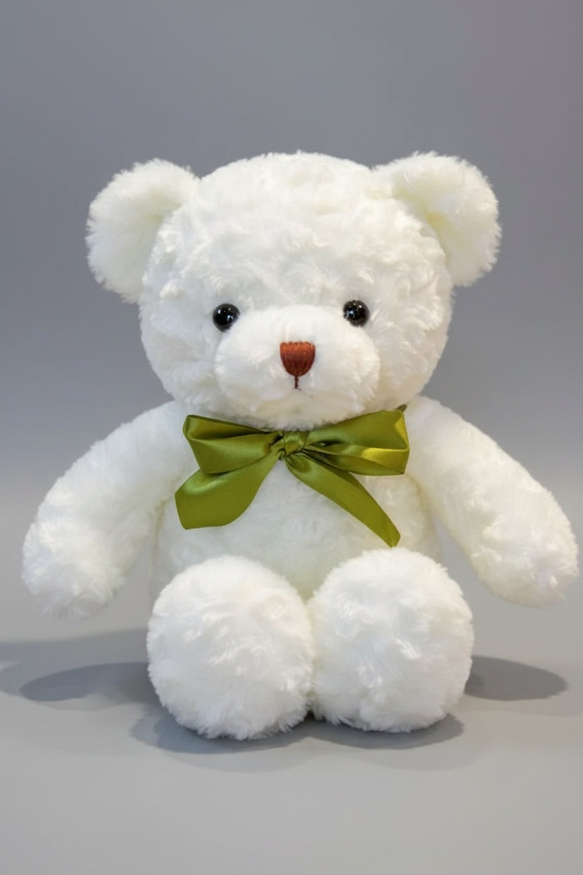 White teddy bear with a green bow tie.