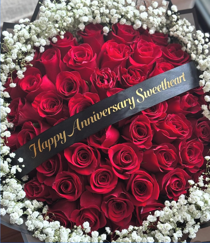 Surrey Round arrangement of red roses with baby's breath flowers